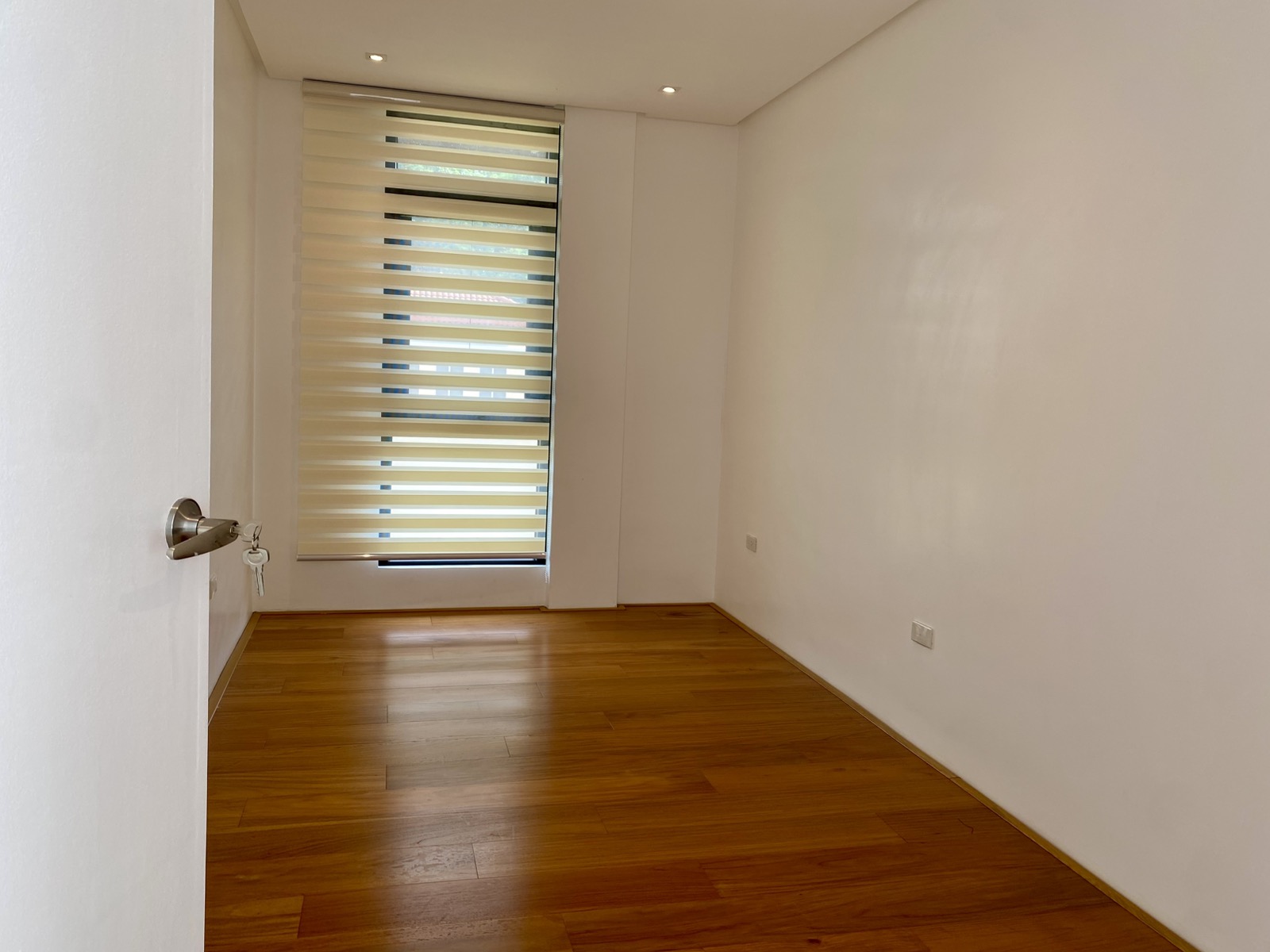 Ground-floor bedroom with combi blinds and wood flooring