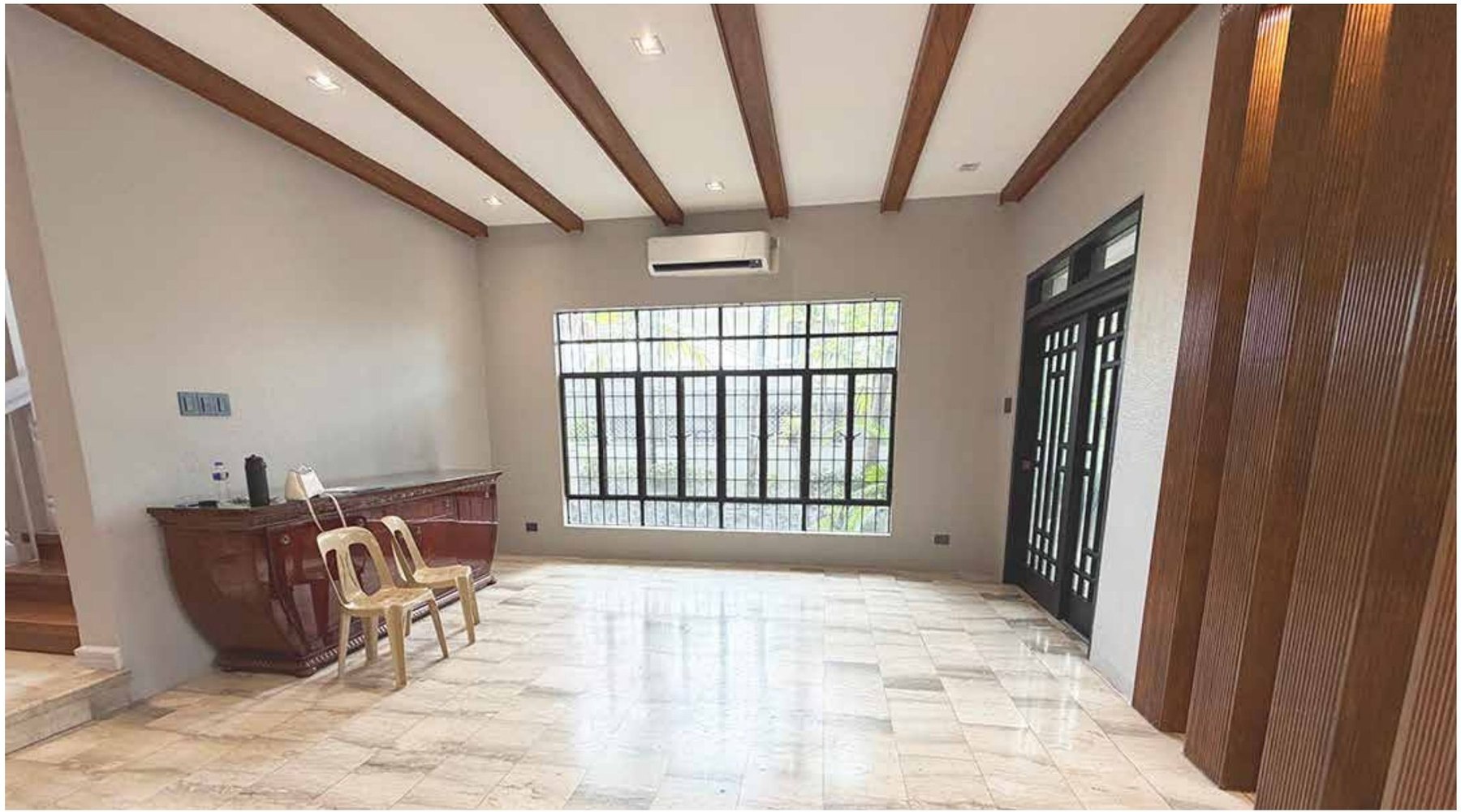 Living area with exposed timber ceiling beams and marble flooring