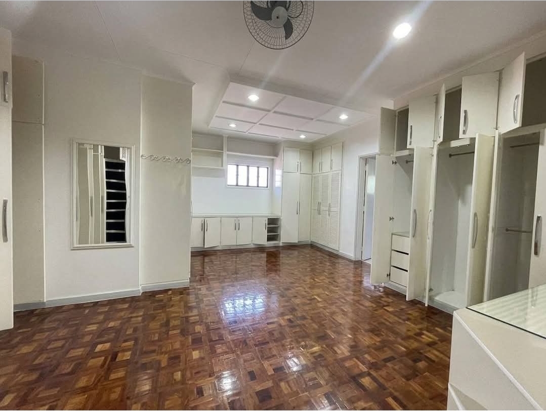 Walk-in closet with fitted wardrobes and parquet flooring