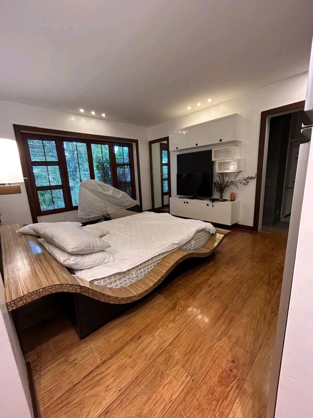 Bright bedroom with built-in media wall and hardwood floors