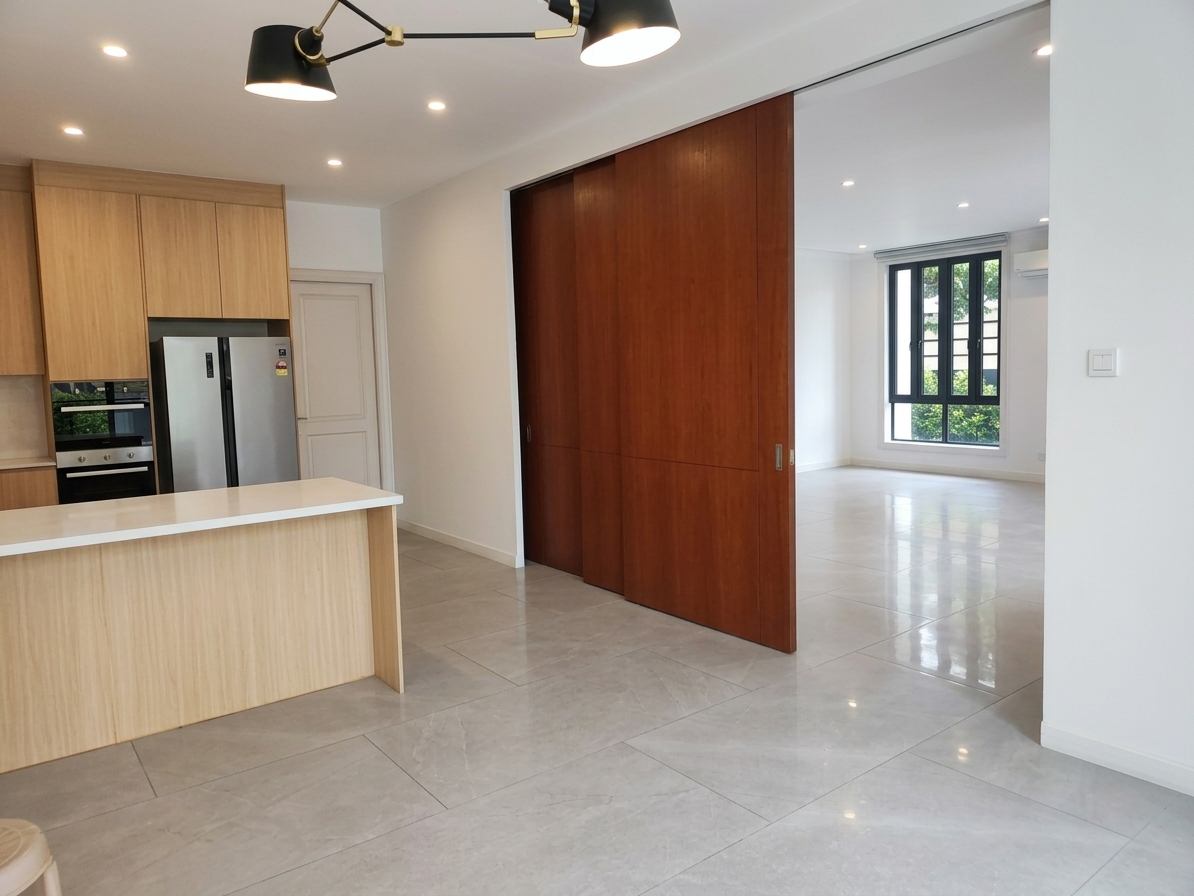 Open kitchen with island, sliding hardwood panels and garden views