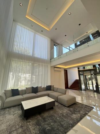 Double-height formal living room with marble floors and floor-to-ceiling sheers